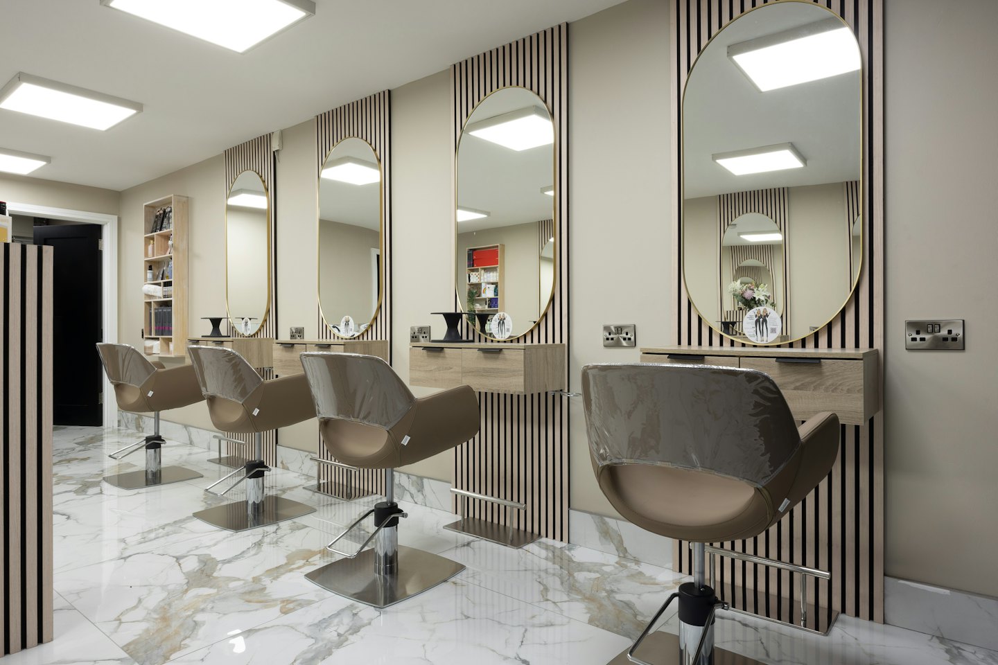 Salone di parrucchiere moderno e vuoto con postazioni per lo styling e pavimenti in marmo.